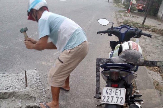 Anh Hùng đục mảng bê tông trên Quốc lộ 1 nhằm tránh tai nạn cho người đi đường