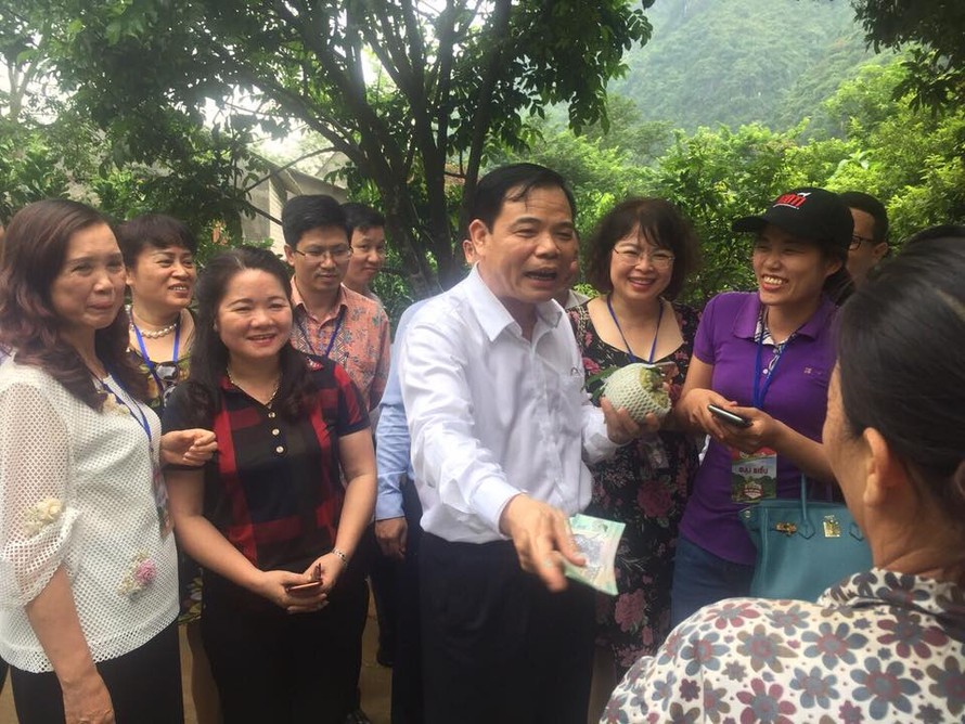 Bộ trưởng Nguyễn Xuân Cường mua na của người dân địa phương. - Ảnh: Hoàng Dự 