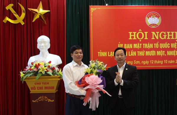 Ông Nông Lương Chấn (bìa trái) nhận hoa chúc mừng của lãnh đạo tỉnh ủy Lạng Sơn *ảnh: Hoàng Huấn