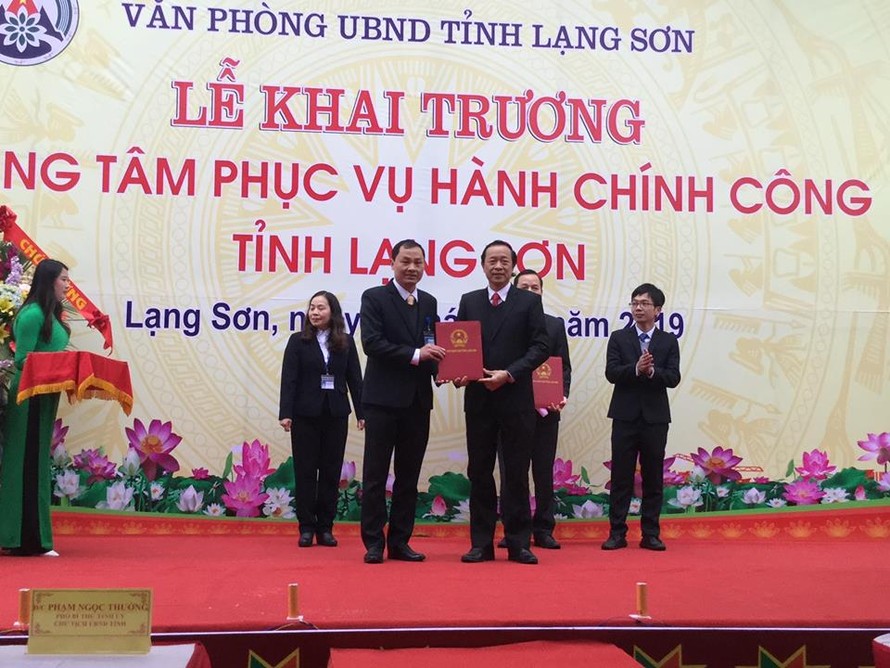 Ông Phạm Hùng Trường (bìa trái) nhận Quyết định bổ nhiệm giám đốc Trung tâm phục vụ hành chính công .Ảnh: Duy Chiến