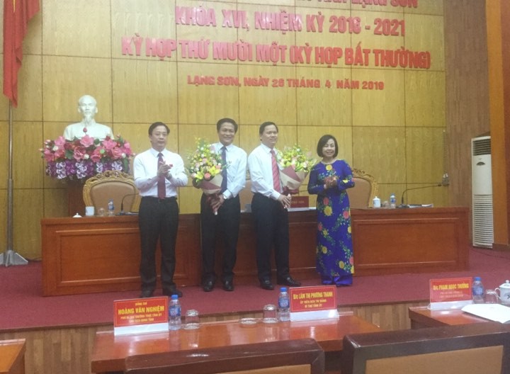 Ông Tô Hùng Khoa (thứ 2 từ trái sang) và ông Hoàng Văn Tài nhận hoa chúc mừng của lãnh đạo HĐND tỉnh Lạng Sơn .Ảnh: Duy Chiến 