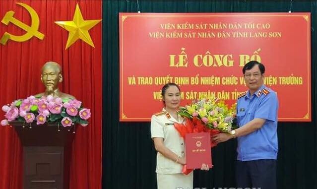 Bà Liễu (bìa trái) nhận hoa chúc mừng của lãnh đạo VKSND tối cao .Ảnh: LS