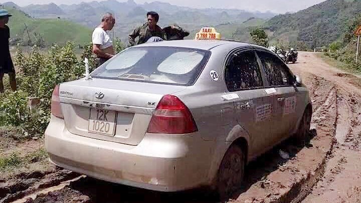 Chiếc xe taxi được tìm thấy ở đoạn đường vắng, sình lầy. Ảnh: TL