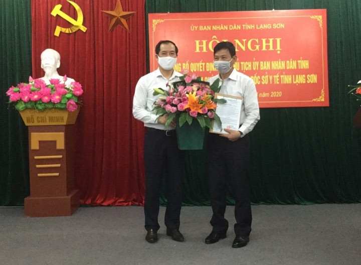 Ông Lý Kim Soi (bìa phải) nhận quyết định và hoa chúc mừng của lãnh đạo tỉnh Lạng Sơn .Ảnh: Duy Chiến