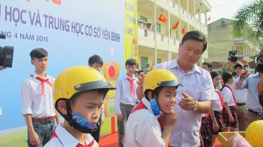 Bộ trưởng GTVT Đinh La Thăng tặng mũ cho học sinh tại buổi lễ