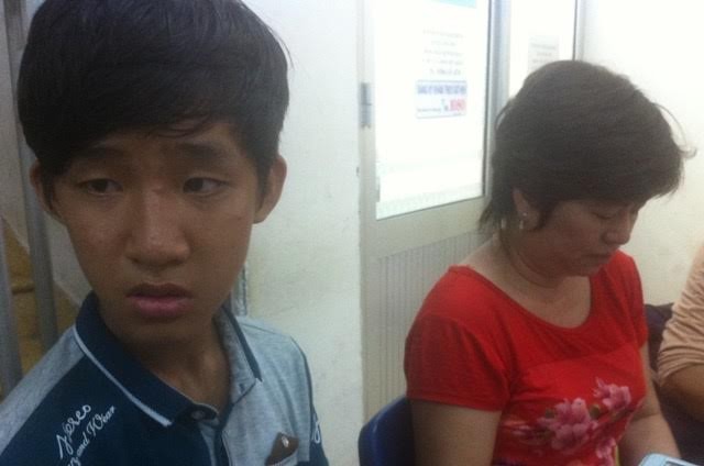 Em Dũng và mẹ đang ngồi chờ thông tin về tình trạng sức khỏe của ông Hùng tại khoa bỏng Bệnh viện Chợ Rẫy. Ảnh: Quốc Ngọc 