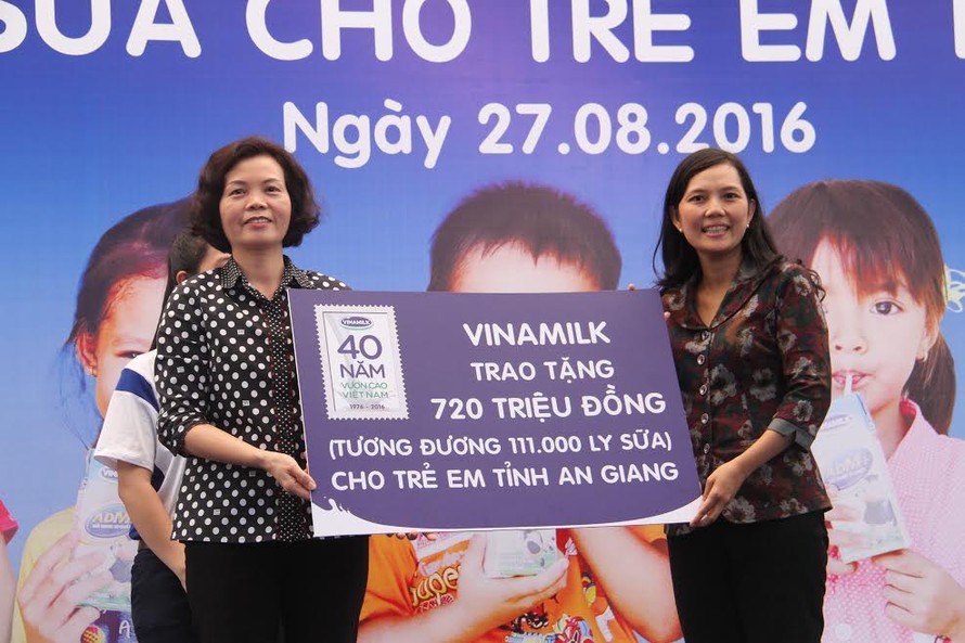Bà Bùi Thị Hương (trái) đại diện Vinamilk trao 111.000 ly sữa cho trẻ em An Giang