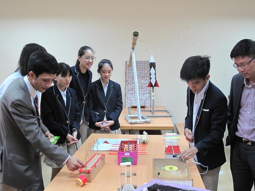 Học sinh và giáo viên trường THPT Phan Huy Chú đang thử nghiệm một sản phẩm của học sinh liên quan đến vật lý - ảnh Nghiêm Huê