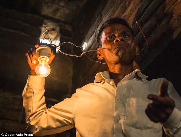 Ông Naresh ngậm dây điện trần có bóng đèn phát sáng