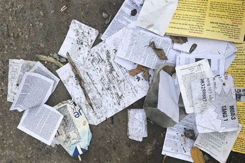 Phao thi lẫn trong đống giấy rác ngoài cổng điểm thi Đại học Công nghiệp Hà Nội. Ảnh: Dương Tâm 