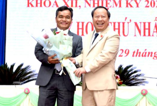 Chủ tịch HĐND tỉnh khóa XI Châu Ngọc Tuấn (áo trắng) tặng hoa chúc mừng Chủ tịch HĐND tỉnh khóa XII Hồ Văn Niên