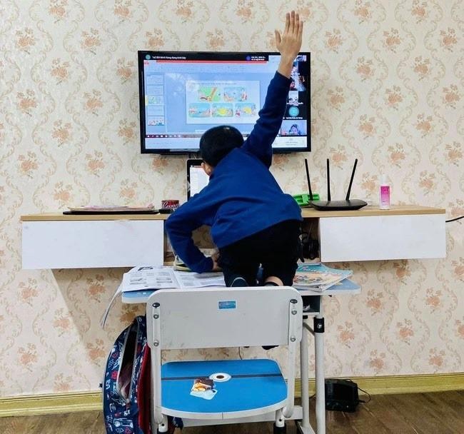 Một học sinh leo cả lên bàn trong giờ học trực tuyến. 