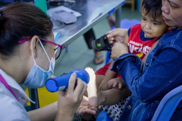 Bác sĩ khám bệnh tay chân miệng cho trẻ tại Khoa Nhiễm, Bệnh viện Nhi đồng 1. Ảnh: Thành Nguyễn. 