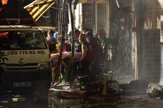Lực lượng cứu hộ đưa thi thể nạn nhân ra xe cứu thương.