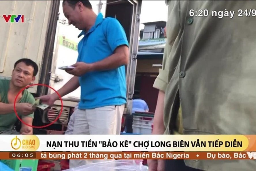 Các PV ghi lại hình ảnh thu tiền bảo kê tại chợ Long Biên. Ảnh cắt clip VTV