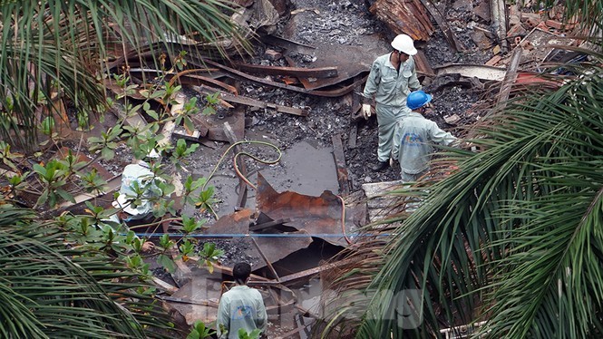 Công nhân vệ sinh môi trường đang thu gom phế thải còn lại sau vụ cháy. Ảnh: Hoàng Mạnh Thắng