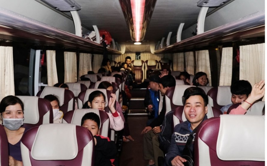 Các gia đình người lao động phấn khởi trên những chuyến xe về quê ăn Tết tại điểm xuất phát Khu công nghiệp Thăng Long. 
