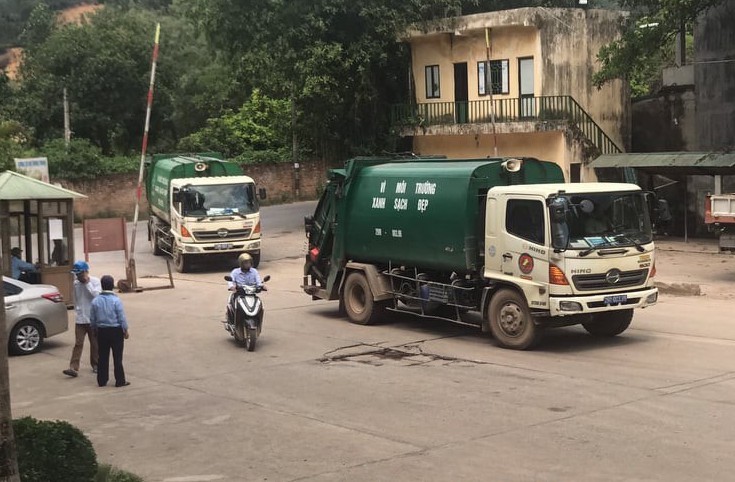 Những chiếc xe rác đầu tiên vận chuyển vào bãi rác Nam Sơn sau khi người dân rút lều lán chăn đường.