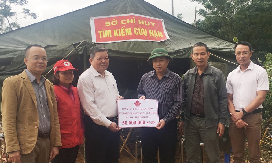 Lãnh đạo Cty CP Đầu tư Lạc Hồng trao tiền hỗ trợ nhân dân bị sạt lở núi tại huyện Tân Lạc.