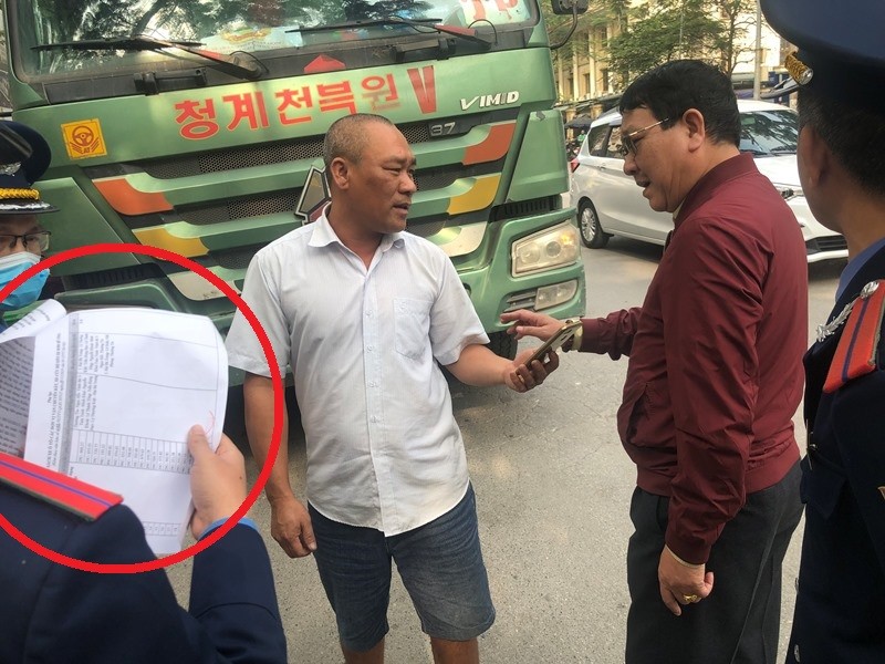 Tài xế vừa trình "lệnh bài" (văn bản chấp thuận của Sở GTVT-vòng tròn đỏ) vừa đưa điện thoại cho lực lượng chức năng nói chuyện với người ở đầu dây bên kia. Với sự chứng kiên của phóng viên, đại diện Thanh tra giao thông Hà Nội đã từ chối nghe.
