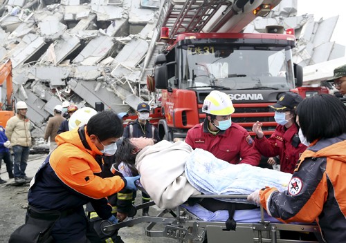 Lực lượng cứu hộ giải cứu một nạn nhân khỏi tòa nhà 17 tầng bị sập ở Đài Nam, Đài Loan. Ảnh: Reuters