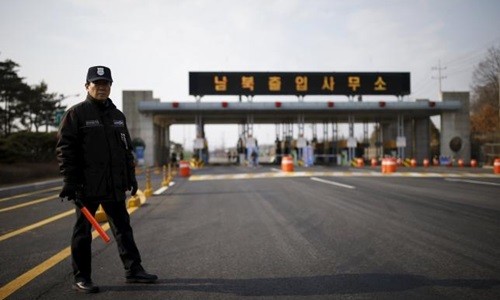 Một nhân viên an ninh Hàn Quốc hôm qua đứng gác trên con đường vắng vẻ dẫn vào khu công nghiệp chung Kaesong. Ảnh: Reuters