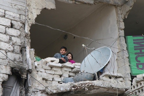 Những đứa trẻ phải sống trong một tòa nhà đổ nát, gần như bị phá hủy hoàn toàn ở Aleppo. Ảnh: AP