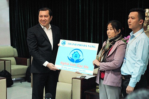Chủ tịch UBND TP Đà Nẵng Huỳnh Đức Thơ trao tặng nhà chung cư cho vợ và con trai thuyền trưởng Vũ Phi Trừ. Ảnh: Nguyễn Đông.