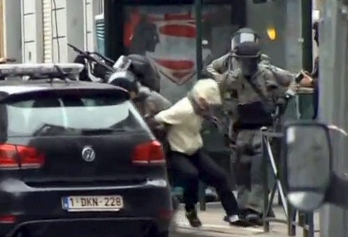Khoảnh khắc một nghi phạm bị bắt tại Molenbeek. Ảnh chụp màn hình: Reuters