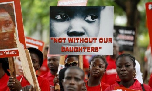 Các nhà hoạt động giơ tấm bảng có dòng chữ "không có các con tôi là không được" vào ngày thứ 500 sau khi các nữ sinh bị bắt cóc, vào ngày 27/8/2015. Ảnh: Reuters