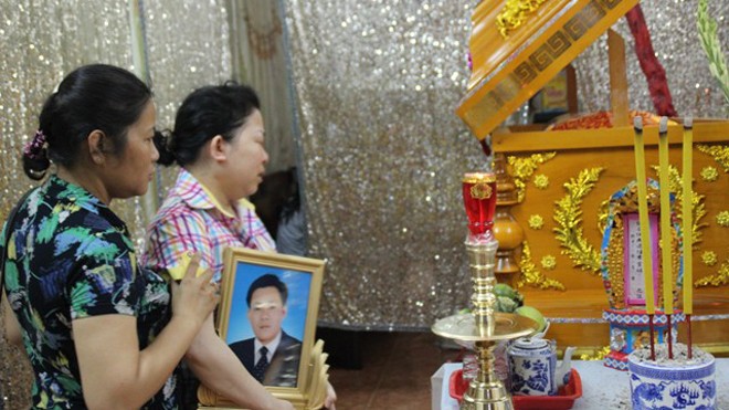 Vợ anh Nguyễn Văn Chín bên quan tài của chồng. Ảnh: PetroTimes