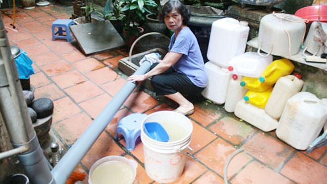 Ngoài việc dùng can đựng nước, bà Bùi Ngọc Châu ở tổ dân phố 35, khu đô thị Định Công (Hoàng Mai) còn nghĩ ra cách nối ống nhựa từ trên tầng thượng xuống bể để hứng nước mưa. Ảnh: Phương Sơn