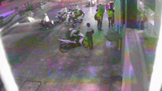 Thanh niên mặc áo khoác nói chuyện với nạn nhân trước khi cướp xe. Ảnh: Cắt từ clip