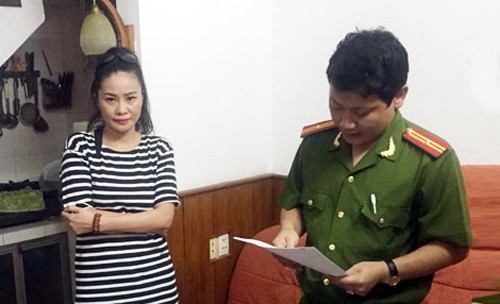 Nghi can Hương Giang nghe cảnh sát đọc lệnh bắt. Ảnh: Công an nhân dân