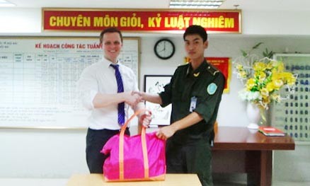 Nhân viên Trung tâm an ninh hàng không Nội Bài trao trả túi xách gồm nhiều tài sản giá trị cho vị khách nước ngoài