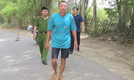 Nguyễn Trung Kiên (áo xanh) đang được đưa về cơ quan điều tra