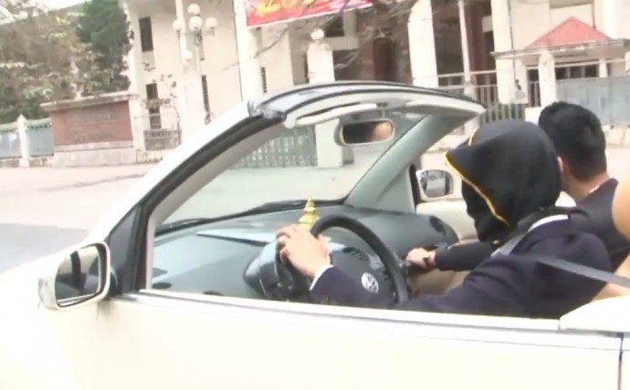 Nam thanh niên trùm chiếc khăn màu đen kín mặt, sau đó điều khiển chiếc ô tô mui trần Volkswagen trên đường Hà Nội