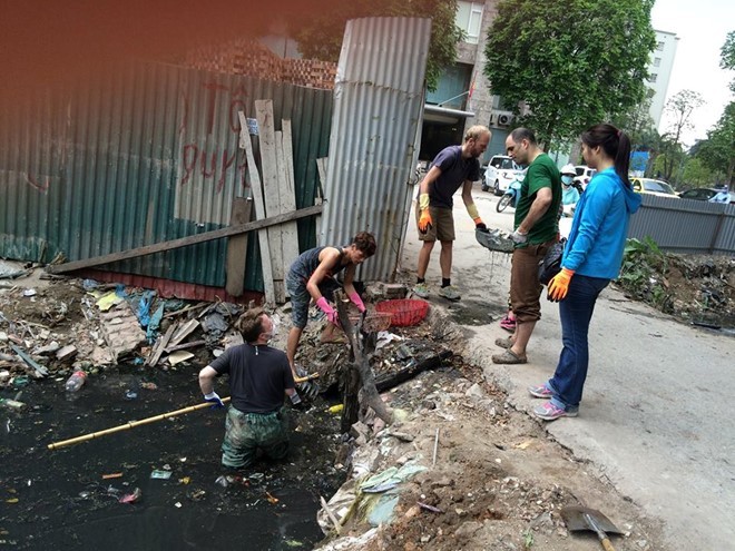 Ba chàng tây tích cực dọn cống bẩn tại phố Nguyễn Khang, Hà Nội. Ảnh: Facebook Mẹ tí