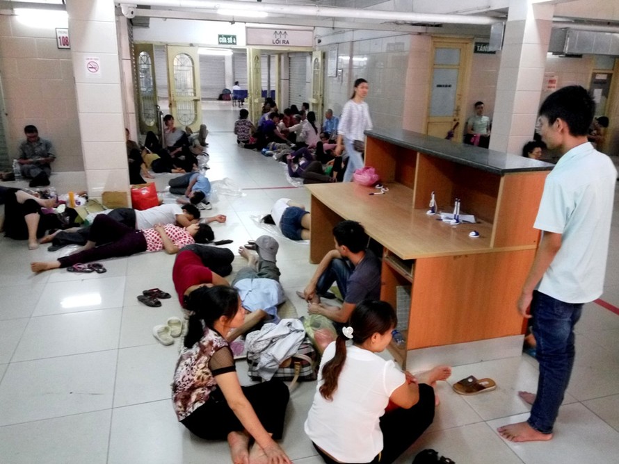 12h trưa, tại khoa Khám bệnh (bệnh viện Bạch Mai) có hàng trăm bệnh nhân và người nhà đứng, ngồi vạ vật khắp các hành lang