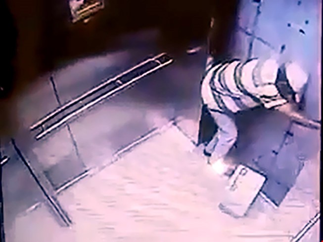 Hình ảnh từ camera an ninh cho thấy ông Tr. đã cố gắng cạy cửa thang máy. Ảnh cắt từ clip