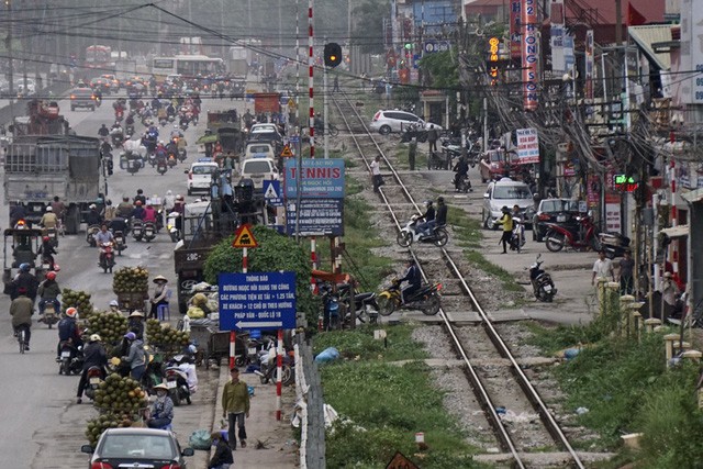 Cảnh đi lại tấp nập của người dân sinh sống ở các khu dân cư hai bên đường tàu hỏa đoạn dọc phố Giải Phóng, hàng ngày phải vượt qua đường ray