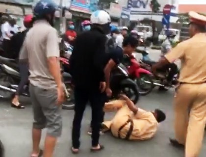 Cảnh sát giao thông bị 3 anh em An xô ngã. Ảnh: Cắt từ video