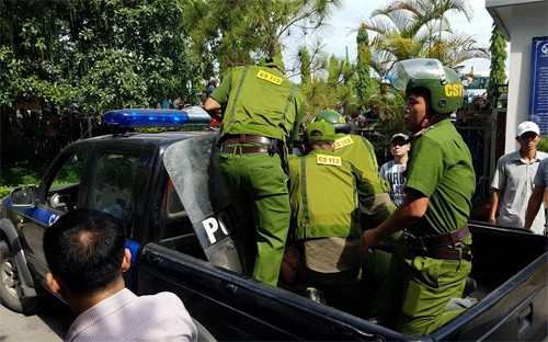 Cảnh sát đưa nam thanh niên lên xe đi về trụ sở