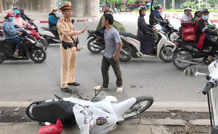 Người đàn ông ngồi sau xe máy sau khi đạp đổ xe máy của tổ công tác đã lao vào tấn công cảnh sát