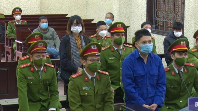 Bị cáo Cao Tài Năng và Vũ Thị Mừng (đeo khăn đứng phía sau) tại phiên tòa. Ảnh: Nguyễn Dương (Dân trí)