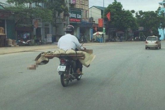 Không tiền, anh Lò Văn Muôn buộc phải chở thi thể em gái về nhà bằng xe máy.