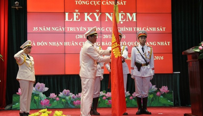Trung tướng Phan Văn Vĩnh gắn huy chương lên quân kỳ của Cục CTCS.