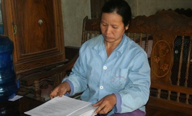 Bà Nguyễn Thị Mai (vợ ông Long) cùng những lá đơn kêu oan cho chồng.