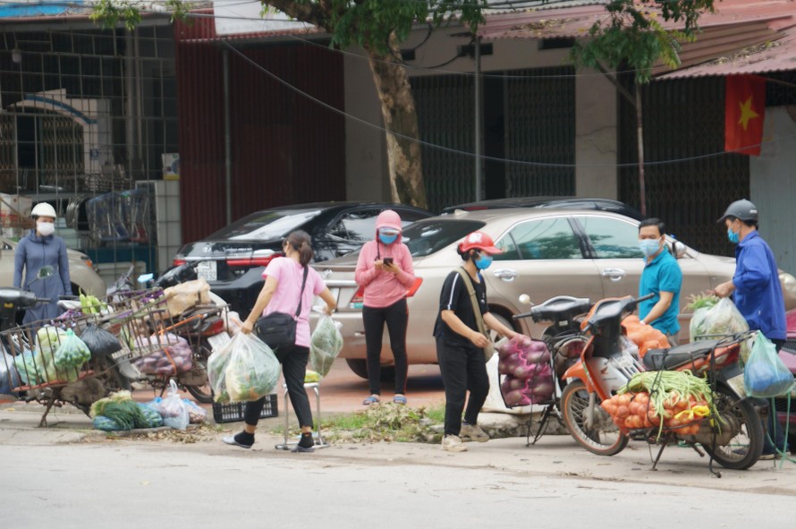 Người dân giao - nhận hàng hóa tại một chốt phong tỏa huyện Việt Yên.