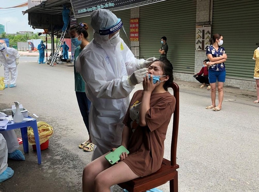 Nhân viên y tế đến tận nhà người dân ở Quang Châu để lấy mẫu xét nghiệm COVID-19.